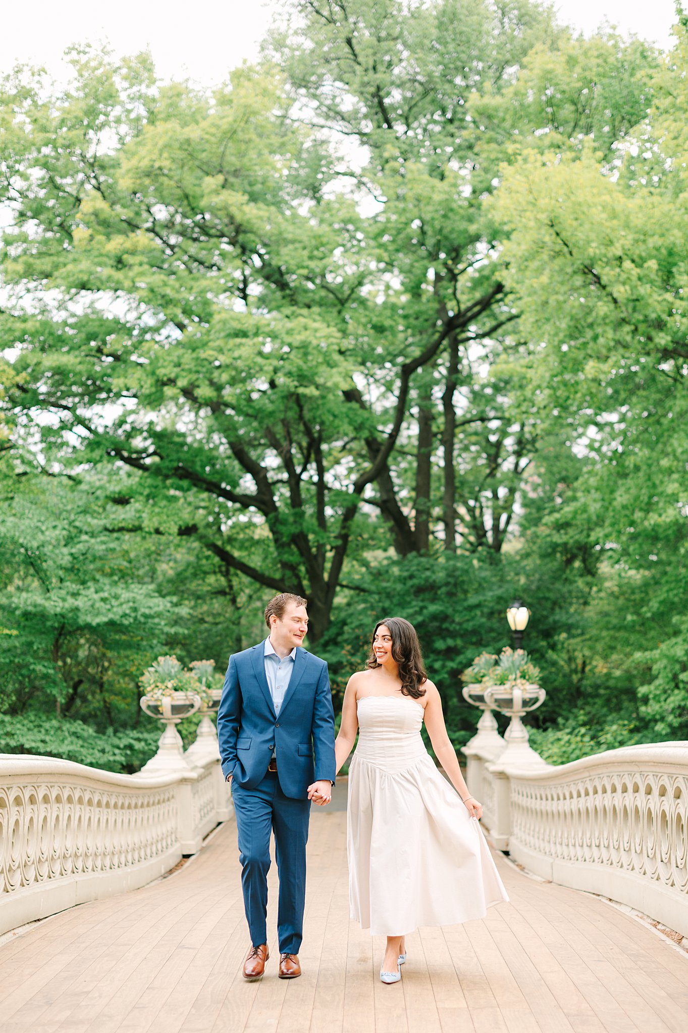 Romantic couple during a spring engagement photo shoot at Bow Bridge in Central Park.